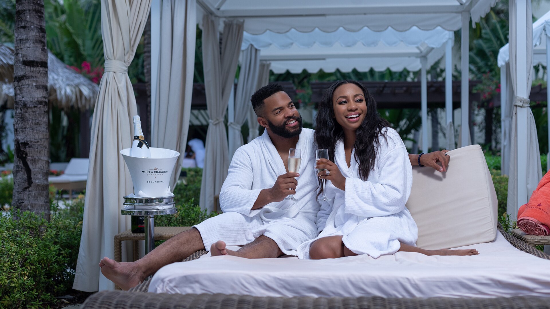 a man and a woman sitting on a bed