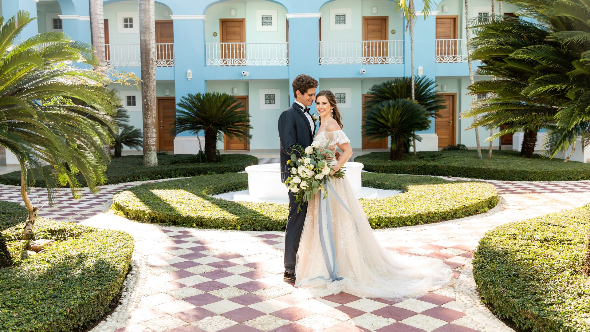 a person standing next to a palm tree in front of a building