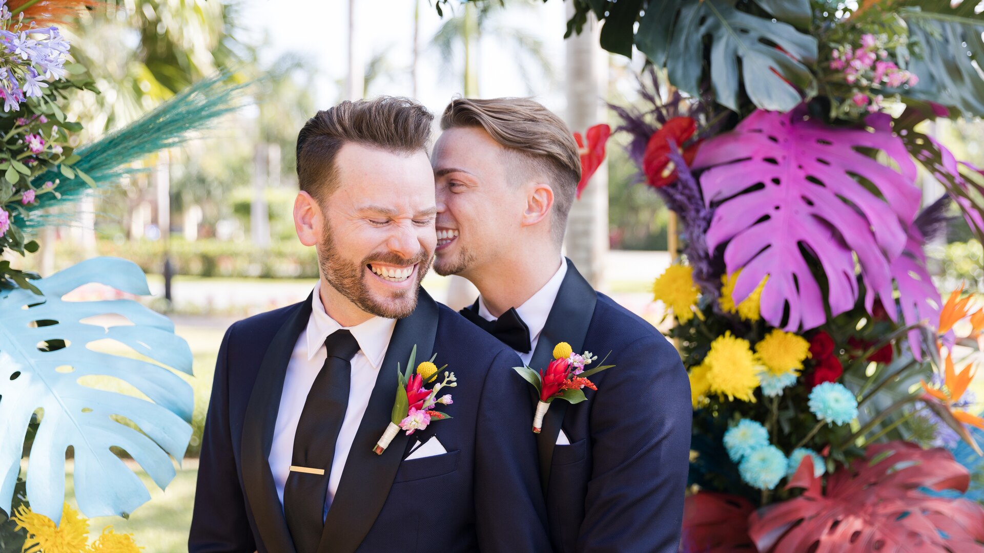 a person in a suit holding a flower