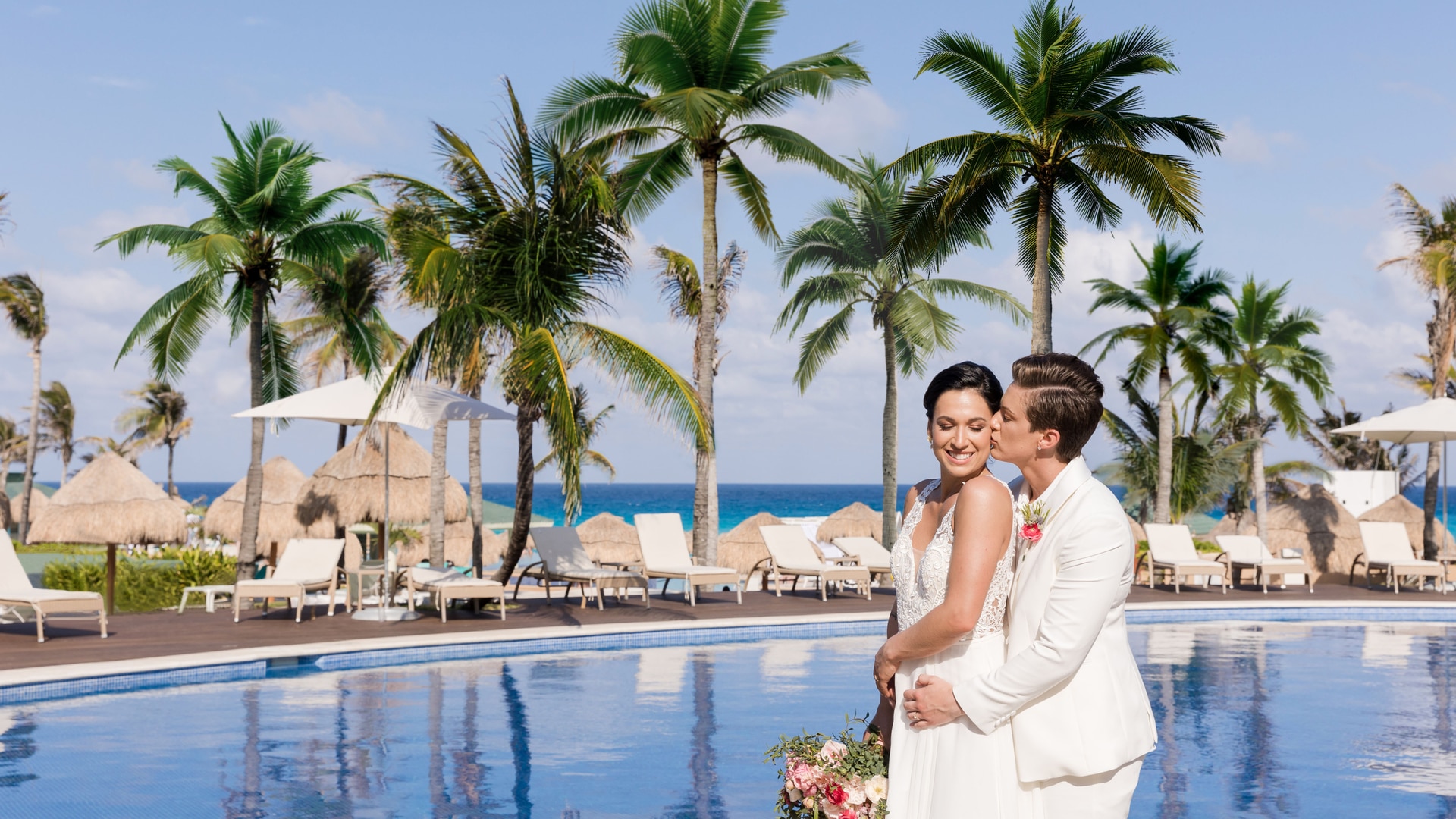 a person standing in front of a palm tree and water