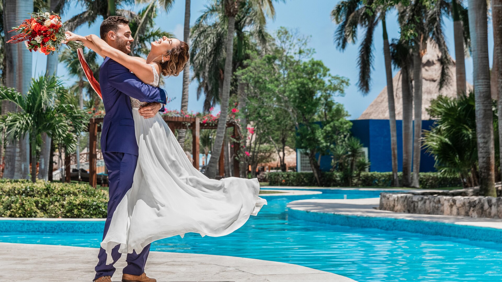 a man in a pool of water in front of a palm tree