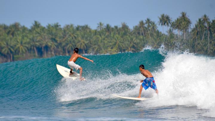 un hombre montando una ola en una tabla de surf en el agua