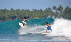 un hombre montando una ola en una tabla de surf en el agua