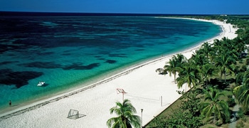 a sandy beach next to a body of water