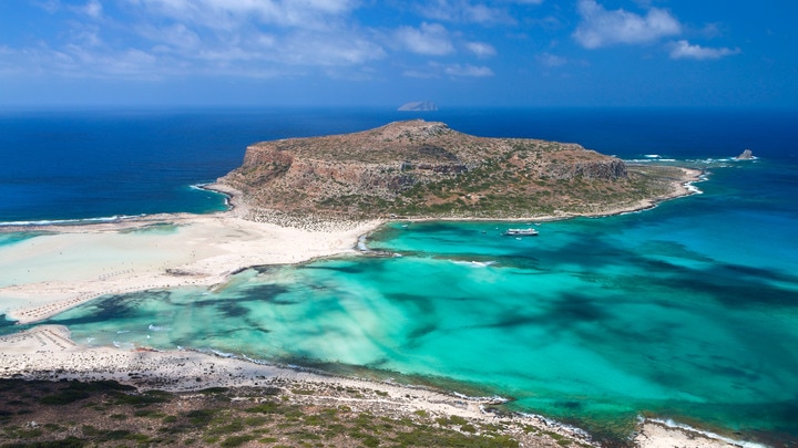 una playa rocosa junto a un cuerpo de agua