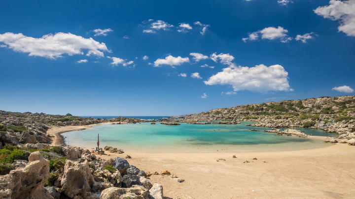 a sandy beach next to a body of water