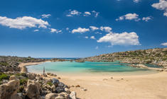 a sandy beach next to a body of water