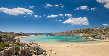 a sandy beach next to a body of water