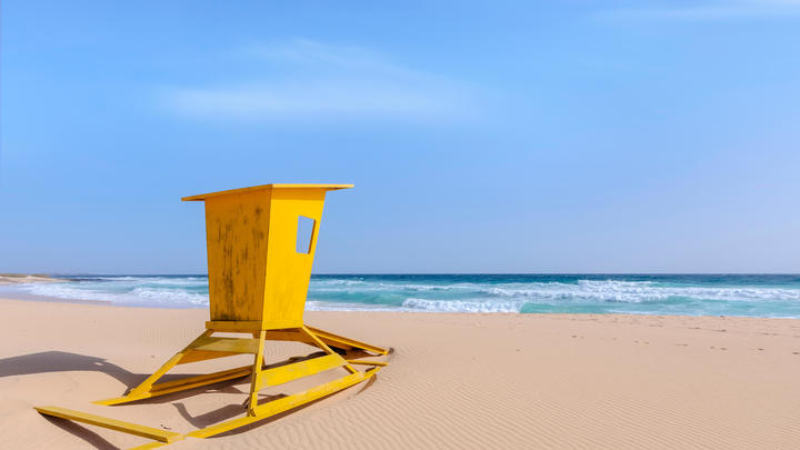 a yellow umbrella sitting on top of a beach