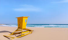 a yellow umbrella sitting on top of a beach