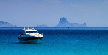 un barco azul y blanco flotando en un gran cuerpo de agua