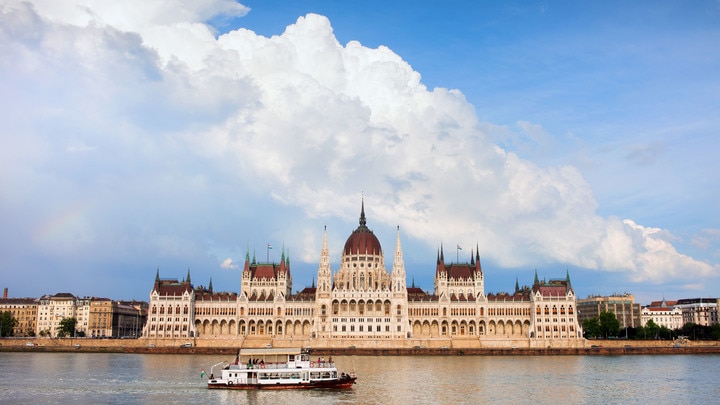 a large ship in the water with Hungarian Parliament Building in the background