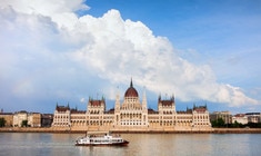 a large ship in the water with Hungarian Parliament Building in the background