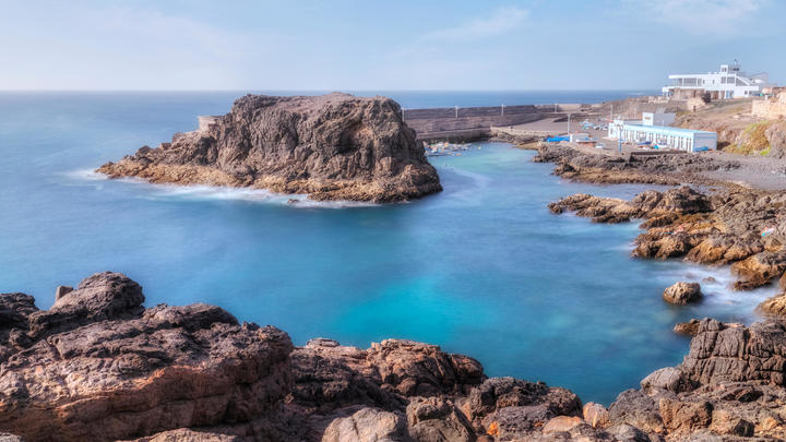 una playa rocosa junto a un cuerpo de agua