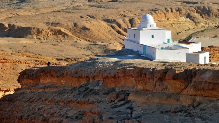 un edificio con una montaña al fondo