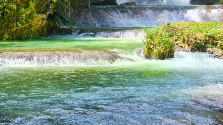 a large waterfall over some water