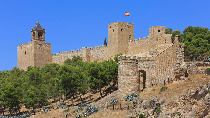 a stone castle next to a brick building