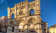 a large stone building with Cuenca in the background