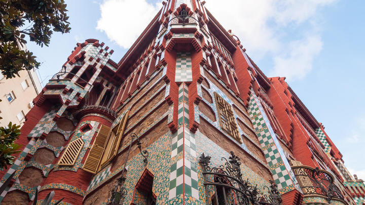 a large brick building with Casa Vicens in the background