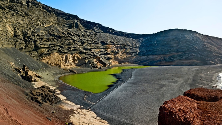 un cuerpo de agua con una montaña en el fondo