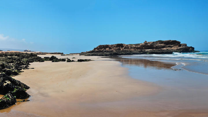 a sandy beach next to the water