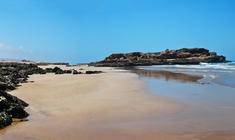 a sandy beach next to the water