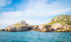 a large body of water with a mountain in the background