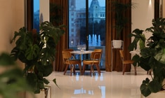 a dining room filled with furniture and vase of flowers on a table