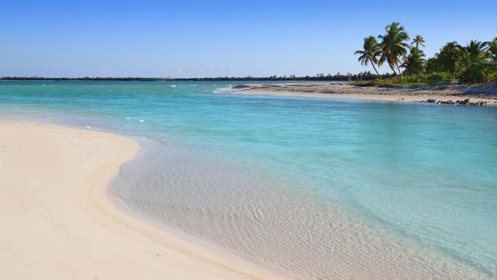 a sandy beach next to a body of water