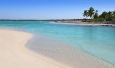 a sandy beach next to a body of water