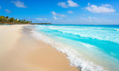 a sandy beach next to a body of water