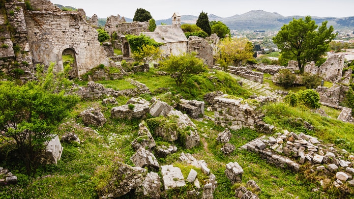 a herd of sheep grazing on a rocky hill