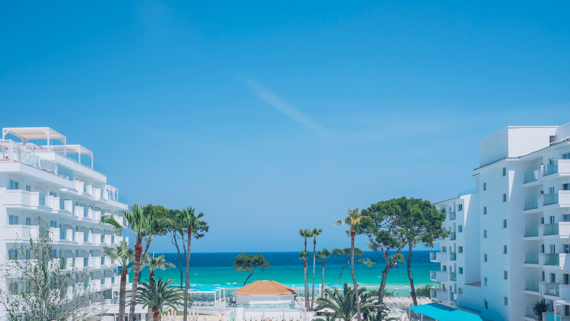 un grupo de sillas de jardín sentado en la parte superior de una playa de arena