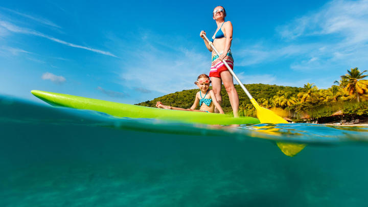 ein Mann, der auf einem Surfbrett im Wasser auf einer Welle reitet