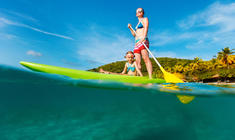 ein Mann, der auf einem Surfbrett im Wasser auf einer Welle reitet