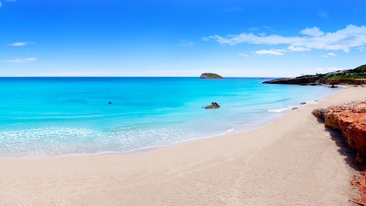 una playa de arena junto a un cuerpo de agua