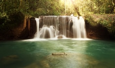 a waterfall cascading into the water in Jamaica