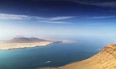 a body of water with a mountain in the background