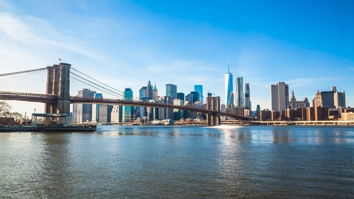 eine Brücke über ein Gewässer mit einer Stadt im Hintergrund