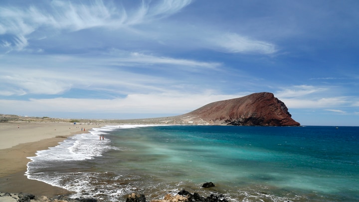 una playa de arena junto a un cuerpo de agua