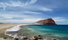 una playa de arena junto a un cuerpo de agua