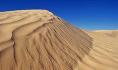 una montaña cubierta de nieve con Dunas de Algodones en el fondo