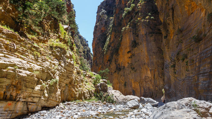 a rocky path with Samariá Gorge in the background