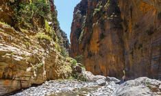 a rocky path with Samariá Gorge in the background