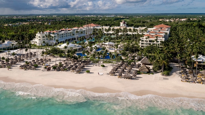 a crowded beach next to a body of water