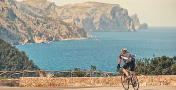 ein Mann, der mit einem Berg im Hintergrund fahrradfährt