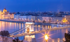 eine lange Brücke über ein Gewässer mit einer Stadt im Hintergrund