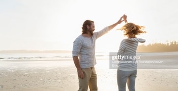 un hombre y una mujer de pie en una playa