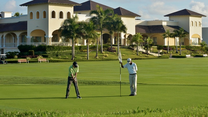 a couple of people that are standing in the grass near a building