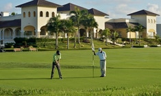 a couple of people that are standing in the grass near a building